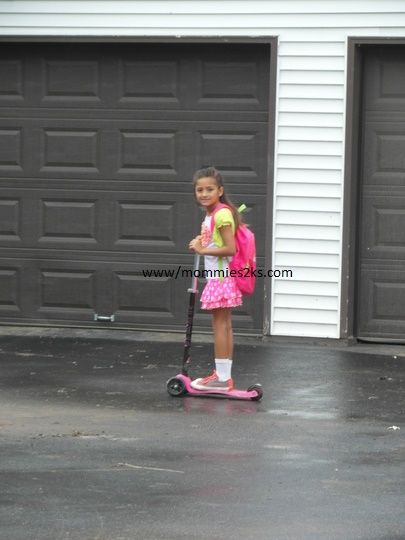 playing with her scooter while waiting for her school bus